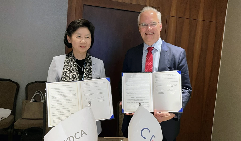 two people holding signed documents to camera